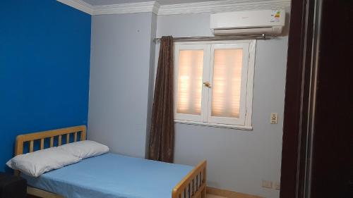 a small bedroom with a bed and a window at A room in an apartment in Nasr City, Cairo, in the eighth district, 15 minutes from Cairo Airport,غرفة بشقة بمدينة نصر بالقاهرة بالحي الثامن 15 دقيقة من مطار القاهرة و 7 دقيقة من معهد الفجر و 12 دقيقة لمعهد ابانة لتعليم اللغة العربية و 26 دقيقة لوسط البلد in Cairo