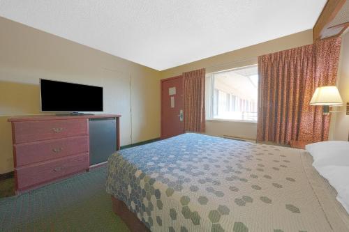 a hotel room with a bed and a flat screen tv at Broadway Inn Portland Downtown in Portland