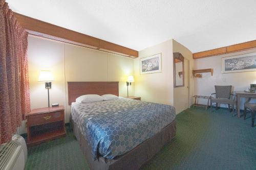 a hotel room with a bed and a table and chairs at Broadway Inn Portland Downtown in Portland