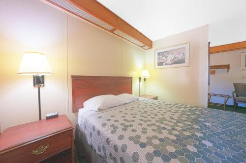 a hotel room with a bed and a table with a lamp at Broadway Inn Portland Downtown in Portland