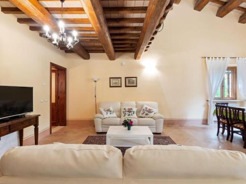 ein Wohnzimmer mit 2 Sofas und einem TV in der Unterkunft Beautiful Villa in Belforte all Isauro with Swimming Pool in Belforte allʼIsauro