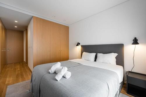 a bedroom with a large bed with two towels on it at GuestReady - A modern retreat in Porto in Porto
