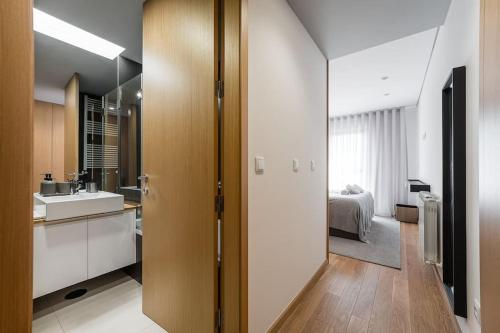 a room with a bathroom with a sink and a bedroom at GuestReady - A modern retreat in Porto in Porto
