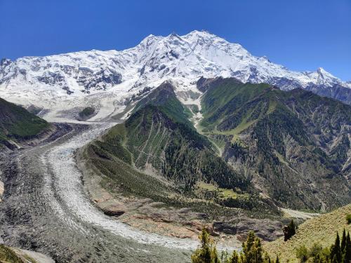 a snow covered mountain with a road in front of it at Rakaposhi Amin Hotel & Restaurant Pissan Hunza Nagar Gilgit Baltistan in Gilgit