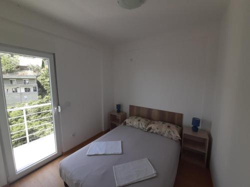 a bedroom with a bed and a large window at Nino Lux Apartments Ulcinj in Ulcinj