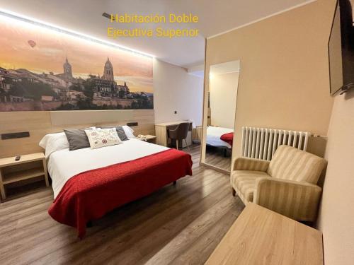a hotel room with a bed and a chair at Hotel Venta Magullo in La Lastrilla
