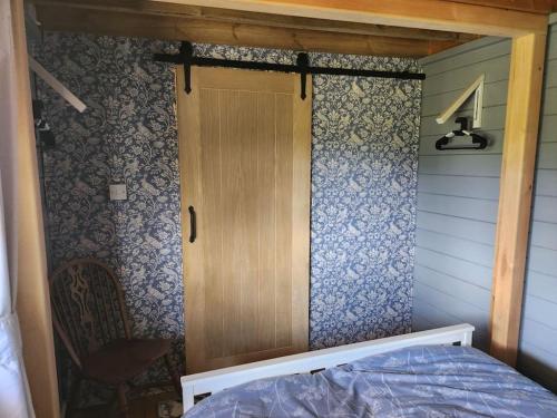 a small room with a door and a bed in it at The Meadow in Lapworth