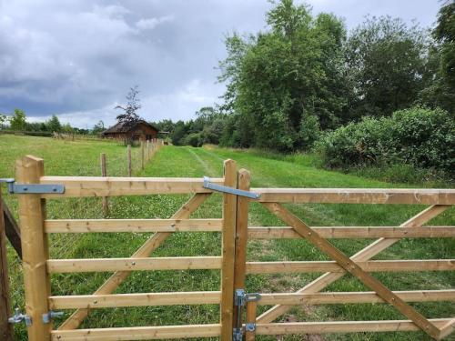 a wooden gate in a field with a field at The Meadow in Lapworth