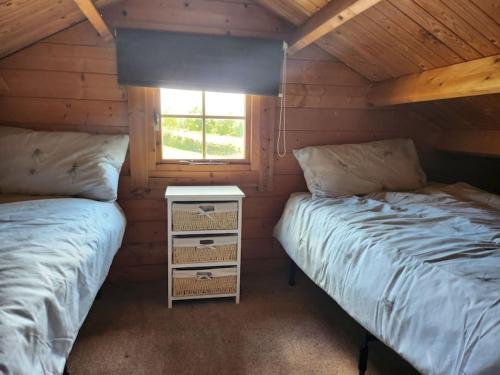 um quarto com 2 camas num chalé de madeira em The Meadow em Lapworth