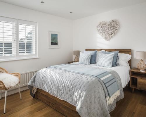 1 dormitorio con 1 cama grande con sábanas azules y blancas en Ocean Beach, en Camber