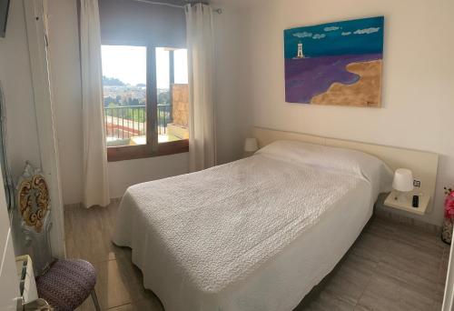 1 dormitorio con cama blanca y ventana en TOSSA DE MAR, MIRAMAR con piscina, en Tossa de Mar