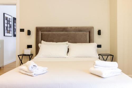 a bedroom with a large white bed with towels on it at Casa Clio in Canton de Fiori in Bologna