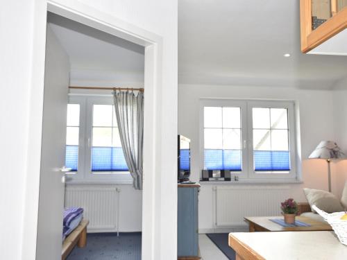 a living room with two windows and a table at Cozy Apartment in Zingst Germany near Beach in Zingst