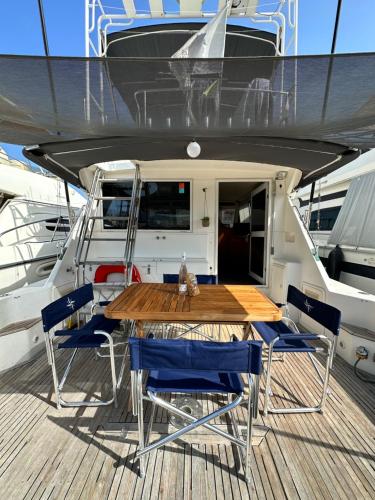 a wooden table and chairs on a yacht at Bateau Vedette 14 mètres in Propriano