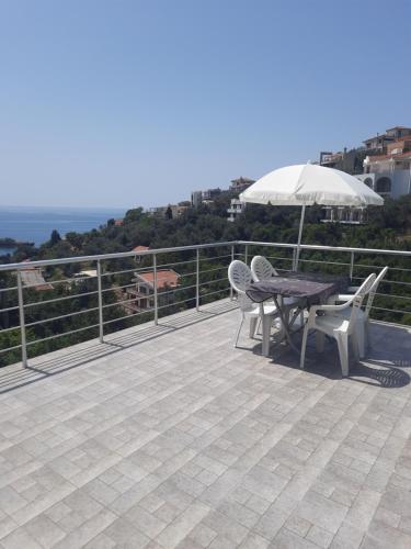 a patio with a table and chairs and an umbrella at Nino Lux Apartments Ulcinj in Ulcinj