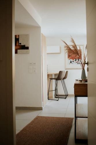 un couloir avec une table et une chaise dans une pièce dans l'établissement Spacieux Appart T3+terrasse, à Aix-les-Bains