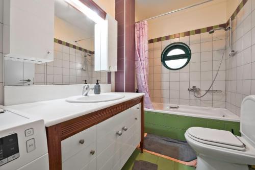 a bathroom with a sink and a toilet and a tub at Marisia Apartments und Villa in Keratokampos