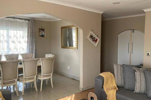 un soggiorno con divano, tavolo e sedie di Home in Suideoord, Jhb south a Johannesburg