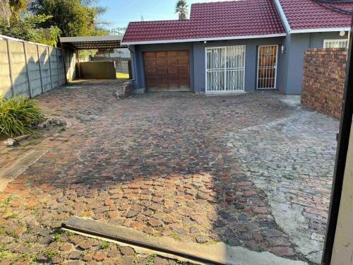 eine Auffahrt vor einem Haus mit Garage in der Unterkunft Home in Suideoord, Jhb south in Johannesburg