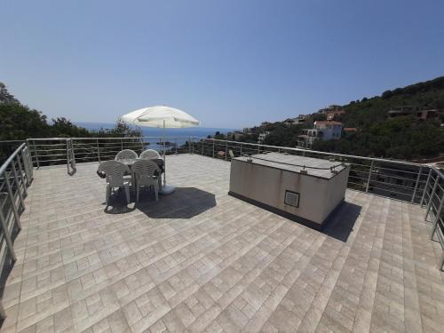 a patio with two chairs and an umbrella on a roof at Nino Lux Apartments Ulcinj in Ulcinj