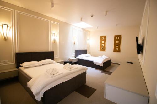 Habitación de hotel con 2 camas y mesa en HOTEL GLAMOUR IMPERIAL en Buzau