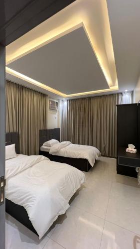 1 Schlafzimmer mit 2 Betten und einer großen Decke in der Unterkunft شقق ميسم الورد للشقق المفروشه in Mahlal