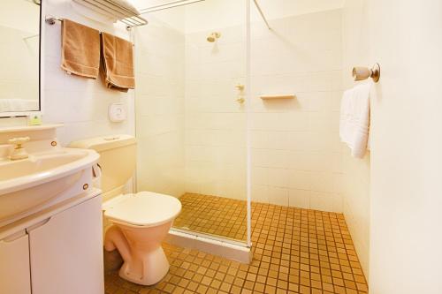 een badkamer met een toilet en een glazen douche bij Armidale Inn in Armidale