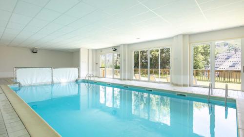 une grande piscine d'eau bleue et des fenêtres. dans l'établissement LES TETRAS - 54 - Chalet lumineux 7 pers, à Saint-Sorlin-dʼArves