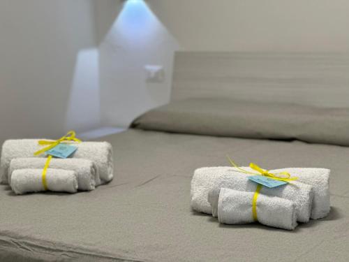 two beds with white towels with yellow bows on them at A do Passi dal Mare in Chioggia
