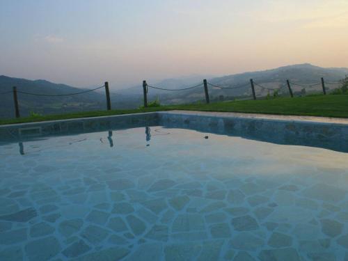 una piscina con una valla y montañas en el fondo en Lovely Holiday Home in Monte Colombo on Farm, en Monte Colombo