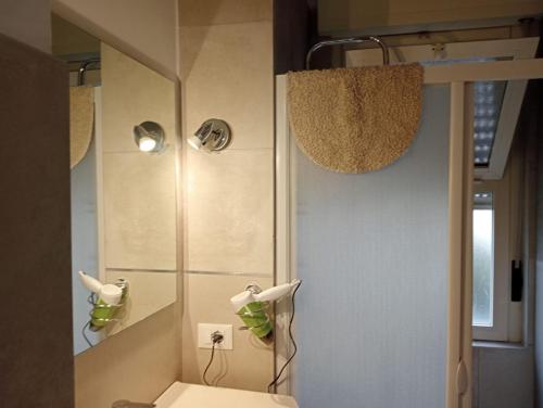 uma casa de banho com um chuveiro, um WC e um espelho. em LiMezzi House em Lecce