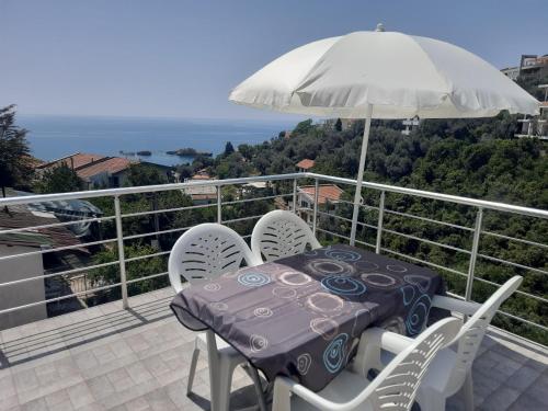 a table and chairs on a balcony with an umbrella at Nino Lux Apartments Ulcinj in Ulcinj