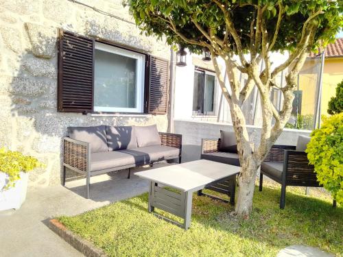 a patio with chairs and a table and a tree at Casa do Chico in Vieira do Minho