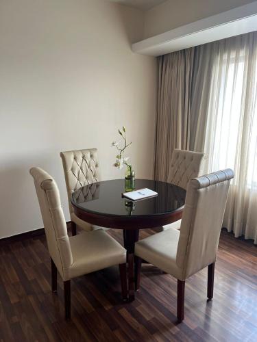 a dining room with a black table and chairs at Hotel Home In By Amrik Sukhdev in Sonīpat