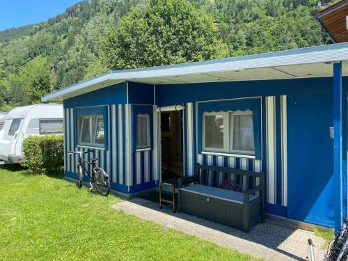 una casa azul con una bicicleta estacionada frente a ella en ***** Camping Aufenfeld - Sonnenglückhütte, en Aschau