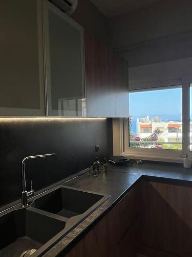 a kitchen with a sink and a window at Elaia Apartment in Kavála