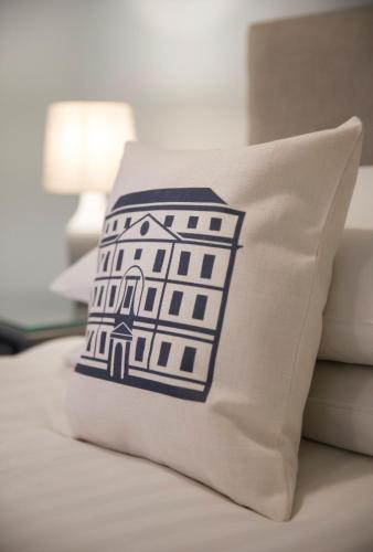 a pillow with a building on it sitting on a bed at The Bar Convent Guest House in York