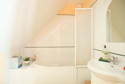 un bagno con vasca e lavandino di La Maison du Bonheur a Saint-Martin-en-Bresse