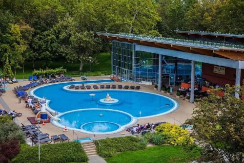 une grande piscine en face d'un bâtiment dans l'établissement MF Port Azúr Wellness Apartments, à Siófok