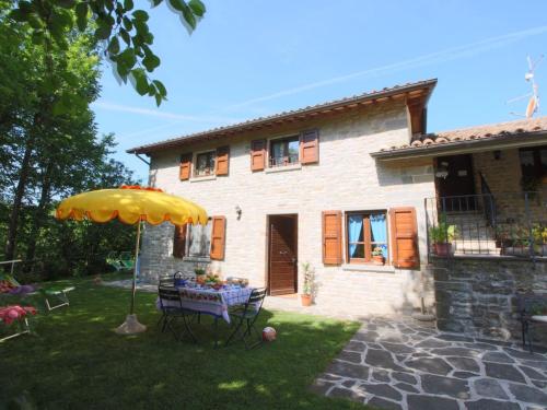 ApecchioにあるCountry Cottage in Marche with Swimming Poolの家の前の傘付きテーブル