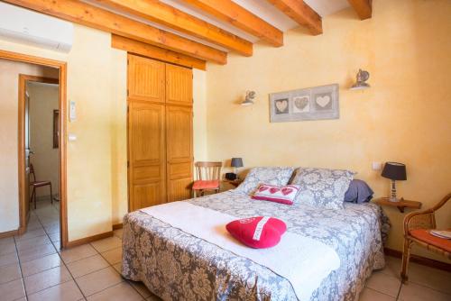 una camera da letto con un letto con cuscini rossi di La Maison du Bonheur a Saint-Martin-en-Bresse