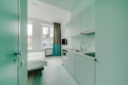 a kitchen with a sink and a bed in a room at New York Laisvės al 51A in Kaunas