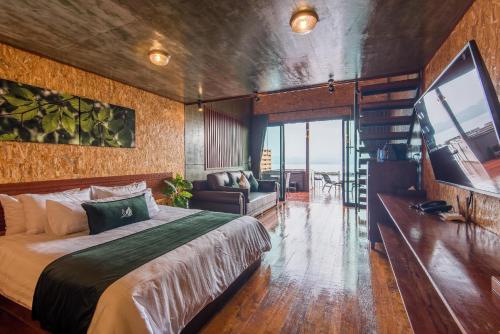 a bedroom with a bed and a living room at ลีฟ เลค กาญจน์ รีสอร์ท in Ban Hin Hak