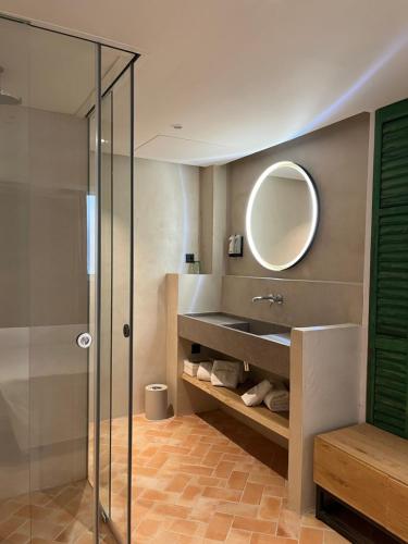 y baño con ducha de cristal y espejo. en Hostal Olga en Sant Antoni de Calonge