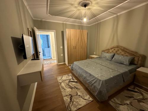 - une chambre avec un lit et une télévision murale dans l'établissement Ledio’s Luxury Apartment, à Pogradec