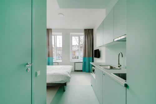 a small room with a bed and a sink at New York Laisvės al 51A in Kaunas