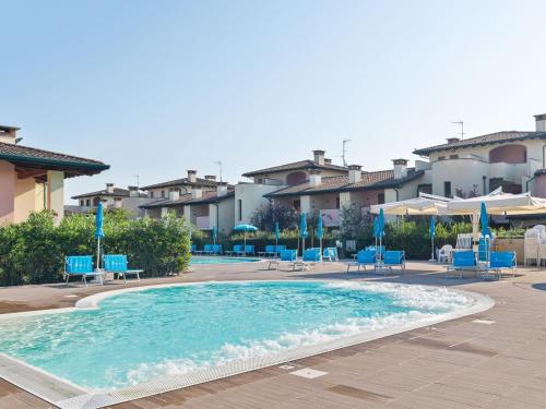 コマッキオにあるCosy Apartment in Lido delle Nazioni with Poolの大きなスイミングプール(青い椅子、パラソル付)