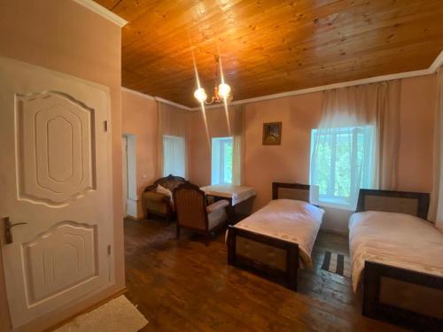 a bedroom with two beds and a wooden ceiling at Seti Tower Guest House in Mestia