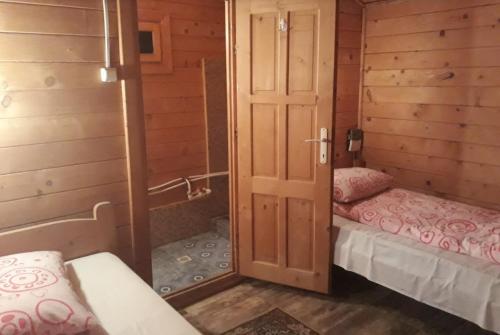 a small room with two beds and a shower at Bungalow- casute in Orşova