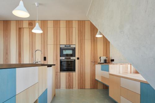 una cucina con armadi in legno e piano cottura. di Sýpka Arnoštov 